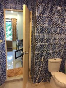 Ban Ko KokHin Suay Nam Sai condominium Rayong的一间带卫生间的浴室和蓝色瓷砖墙壁。