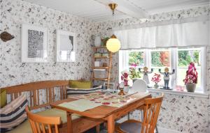 奇维克Amazing Home In Kivik With Wifi的一间带木桌和椅子的用餐室