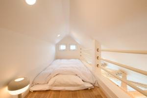 箱根和光荘 Harmonious Light West的一间位于阁楼的白色卧室,配有床铺