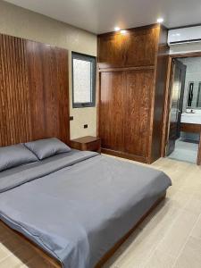 Green Bay Luxury Villa Sonasea Vân Đồn的一间卧室设有一张带木墙的大床