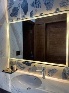 Green Bay Luxury Villa Sonasea Vân Đồn的一间带水槽和大镜子的浴室