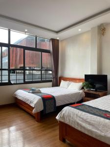 萨帕TUONG MAI HOTEL的一间卧室设有两张床和大窗户