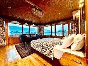 斯利那加新杰奎琳遗迹船屋酒店的一间设有床铺的卧室,位于带窗户的房间内