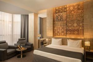 埃里温埃里温共和酒店的配有一张床和一把椅子的酒店客房