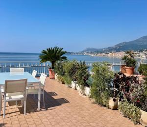 文蒂米利亚Una terrazza sul mare - Balzi Rossi的一个带桌椅的庭院和大海