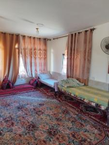 Şirfahprivate room with cultural experience and great landscapes的一间设有两张床、窗帘和地毯的房间