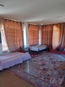 Şirfahprivate room with cultural experience and great landscapes的一间卧室配有两张床、窗帘和地毯。