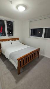 墨尔本3 bedroom condo opposite casino.的一间卧室设有木床和2个窗户。