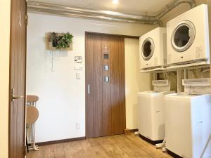 七饭YUKARA LEAF LODGE的通往带洗衣机和烘干机的洗衣房的门