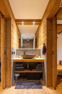 卡尔蒂奇Chalet Heidi的一间带水槽和木墙的浴室