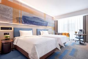 青山武汉高铁站希尔顿欢朋酒店的酒店客房配有两张床和一张书桌