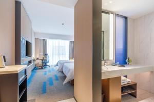青山武汉高铁站希尔顿欢朋酒店的酒店客房设有床、水槽和镜子