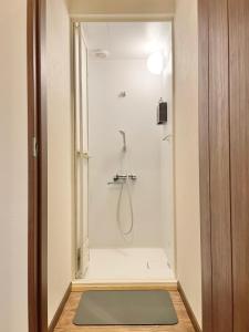 七饭YUKARA LEAF LODGE的带淋浴的浴室(铺有绿色地毯)