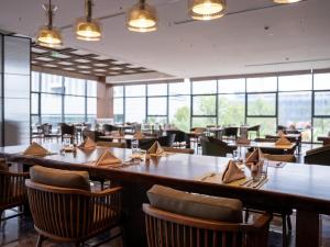 徐州徐州喜来登酒店的餐厅设有木桌、椅子和窗户。