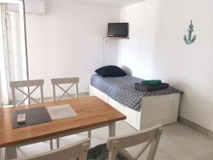 诺瓦利娅Apartments Silver的小房间设有一张床、一张桌子和椅子