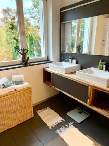 韦齐孔Gästehaus Casa Cecilia的一间带两个盥洗盆和大镜子的浴室