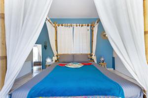 阿尔让河畔皮热Appartement jacuzzi 4 étoiles - Love Room Beauté的一间卧室配有蓝色的床和白色窗帘