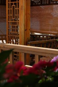 丽江夕露星期六智能度假花苑的前方有粉红色花的木凳