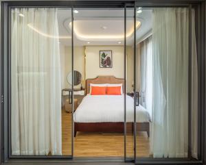 胡志明市Simmi Apartment Phu My Hung的一间卧室配有带橙色枕头的床