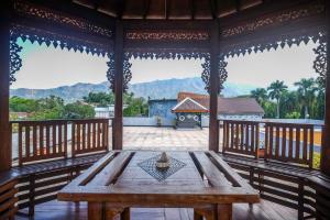 马格朗Urbanview Syariah Wisma Wongso Borobudur的门廊上的木桌,享有房子的景色