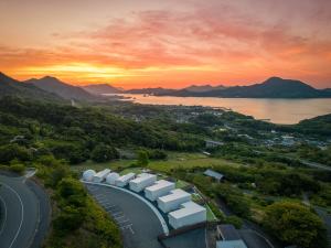 尾道市LEMON FARM GLAMPING simanami的享有道路的空中景色,背景是日落