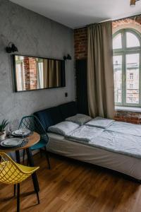 罗兹VS Apartments - apartament nr 34的一间卧室配有一张床、一张桌子和一个窗户。