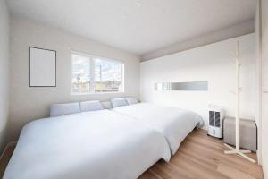 旭川THE Prestige的白色的卧室设有一张白色大床和一个窗户。