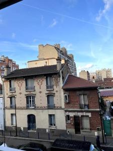 奥贝维利埃Luminous appartment in Paris with balcony的城市街道上的一座旧砖砌建筑