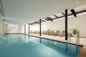 卡尔达罗塔尔霍夫艾希酒店的一座带椅子的建筑内的游泳池