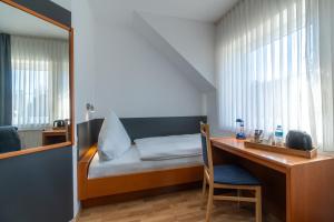 阿豪斯Landhotel Elkemann的小房间设有一张床和一张桌子及椅子