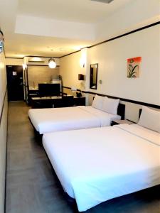 宿务Toyoko Inn Cebu的酒店客房设有三张床和一架钢琴