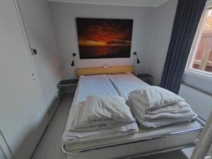 博里霍尔姆图勒嘉坦24号宾馆的卧室内的一张床铺,墙上有绘画作品