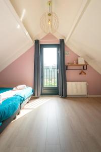 Ewijk6P Vrijstaand Huis met royale tuin en Hottub的一间卧室设有一张床和一个大窗户