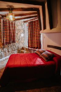 贝瑙卡斯罗斯克索斯度假屋的一间卧室设有红色的床和窗户。