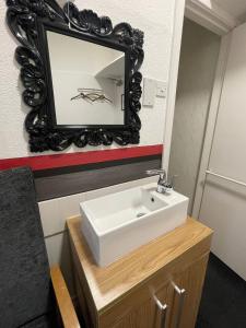 布莱克浦曼哈顿酒店的浴室设有水槽和墙上的镜子