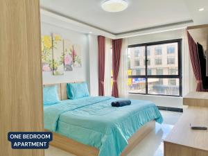 金边WH Chamkarmon Residence的一间卧室配有一张带蓝色床单的床和一扇窗户。