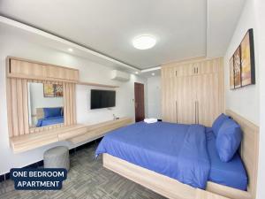 金边WH Chamkarmon Residence的一间卧室配有蓝色的床和一台平面电视