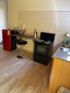 吕德里茨The Oasis Accommodation的厨房配有炉灶和带凳子的台面