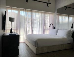 香港Southside by Ovolo的卧室设有白色的床和大窗户