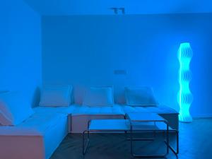 上海ZHome-Three floors 4 bedrooms - near Nanjing Road的带沙发和蓝色灯光的客厅