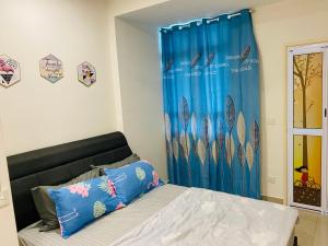 峇六拜Spice Tunas House的一间卧室配有一张蓝色窗帘的床