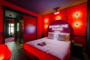 阿姆斯特丹SUPPER Hotel的红色卧室,配有一张带标志的床