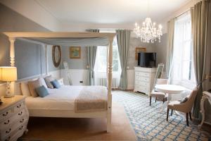 赫默尔亨普斯特德谢迪希庄园酒店的一间卧室配有一张天蓬床和一张书桌
