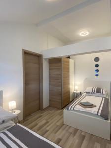 大戈里察Albert apartments Zagreb airport的白色卧室设有一张大床和木地板