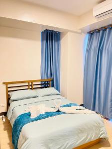 Punta EngañoMactan Newtown 2 Bedroom near Mactan Airport的一间卧室配有2张蓝色窗帘