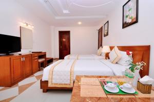 胡志明市谭晃龙酒店的配有一张床和一台平面电视的酒店客房