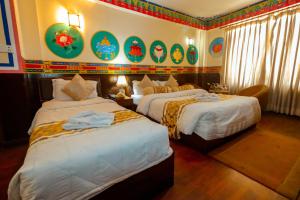 加德满都加德满都生态酒店的酒店客房设有两张床,墙上挂有绘画作品