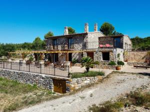 卡瓦内斯La Cueva de Miravet - villa de lujo en la cima de la montaña con vistas al mar的一座古老的石头房子,前面有栅栏