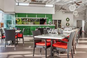 卡门港卡门俱乐部钻石度假村的一间带桌椅的用餐室和绿色酒吧