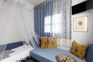 卡拉马塔Best Located Melina Escape的窗户客房内的蓝色沙发